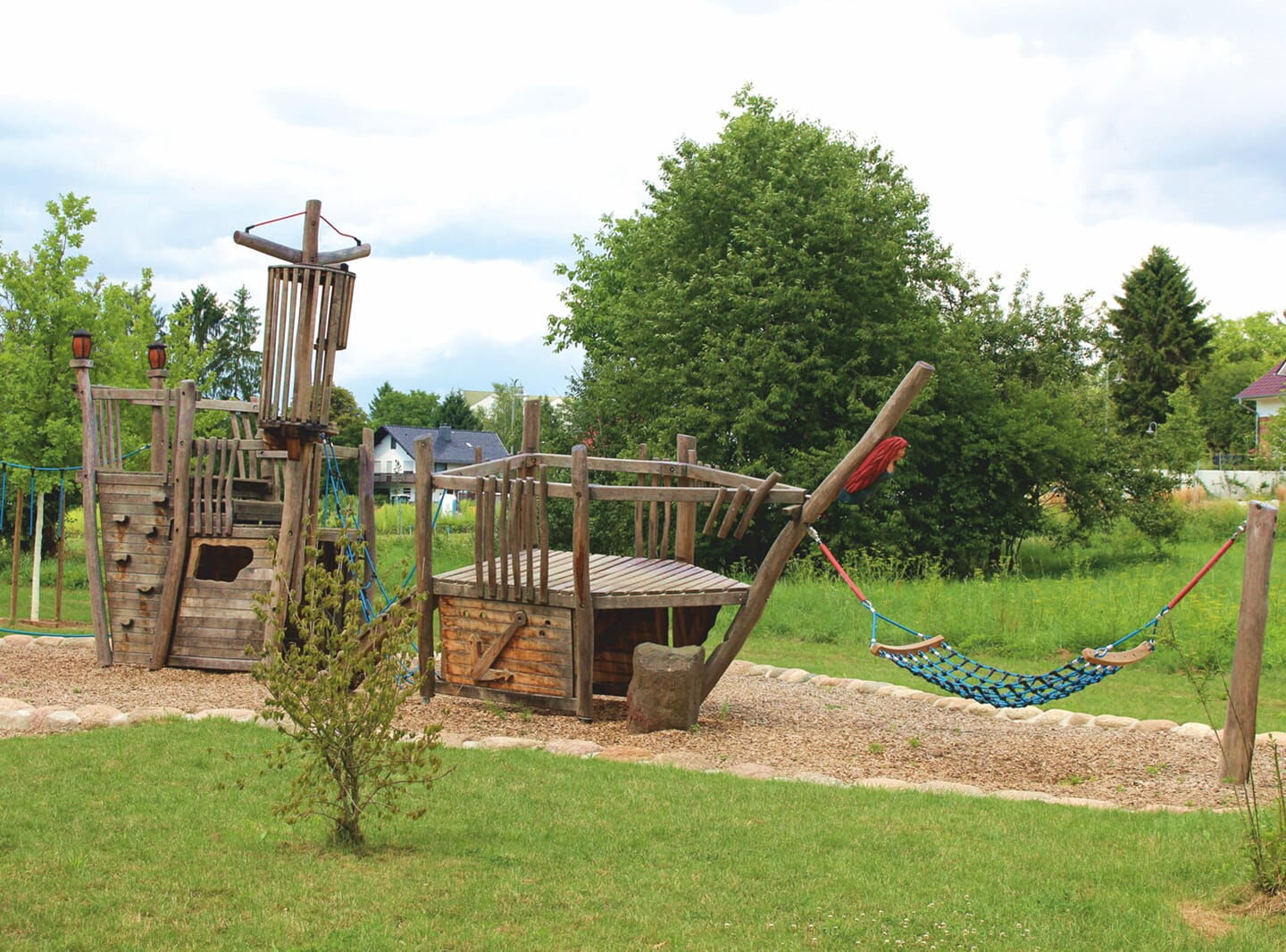 Spielplatz mit Hängematte, Holzschiff und Kletterturm